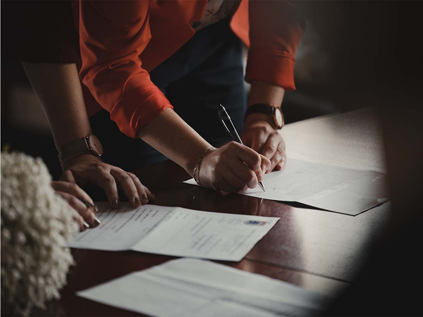 Two coworkers working on business documents at desk