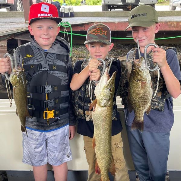 three boys holding different fish About.jpg