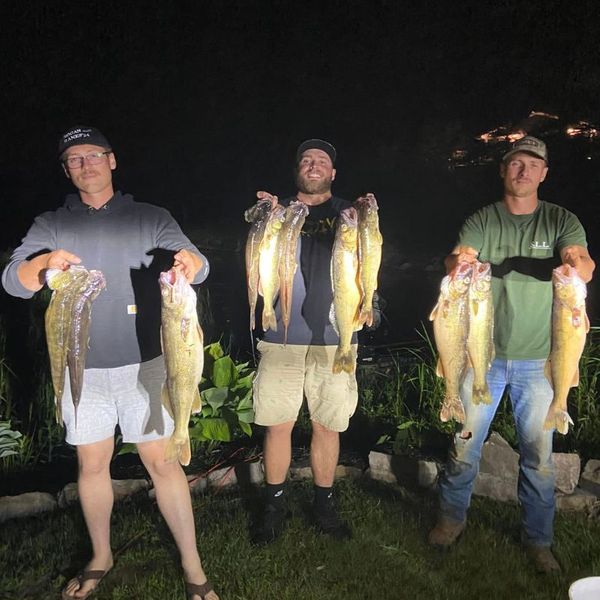 three men at night holding multiple fish Dinner.jpg