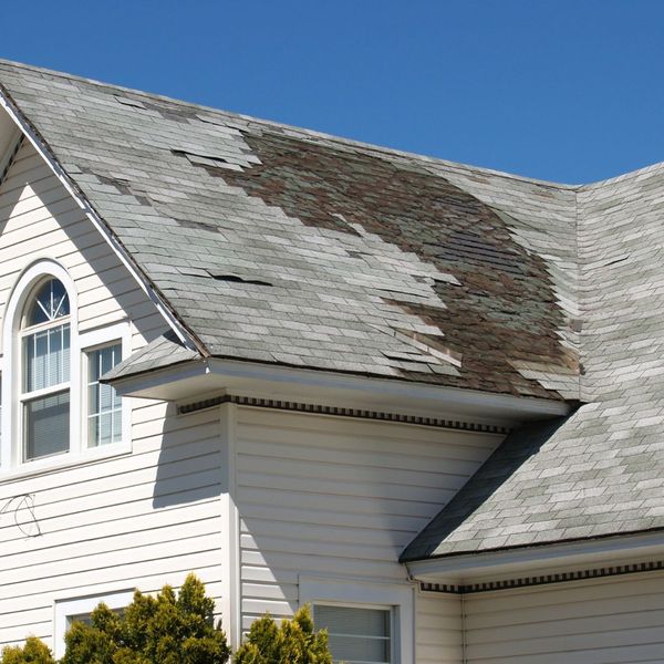 Roof with large patch of shingles missing or worn