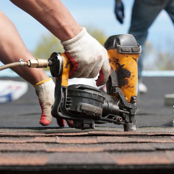 Man nails roof shingles