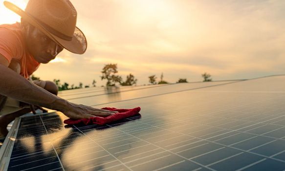 Person wiping down solar panel