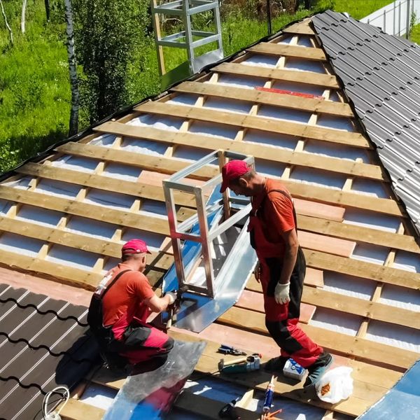 Roofing contractors install new roof around chimney