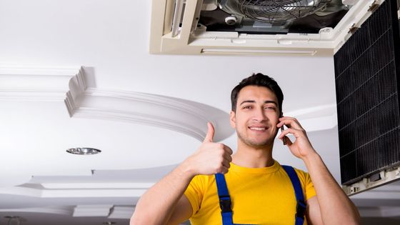 man fixes AC Unit