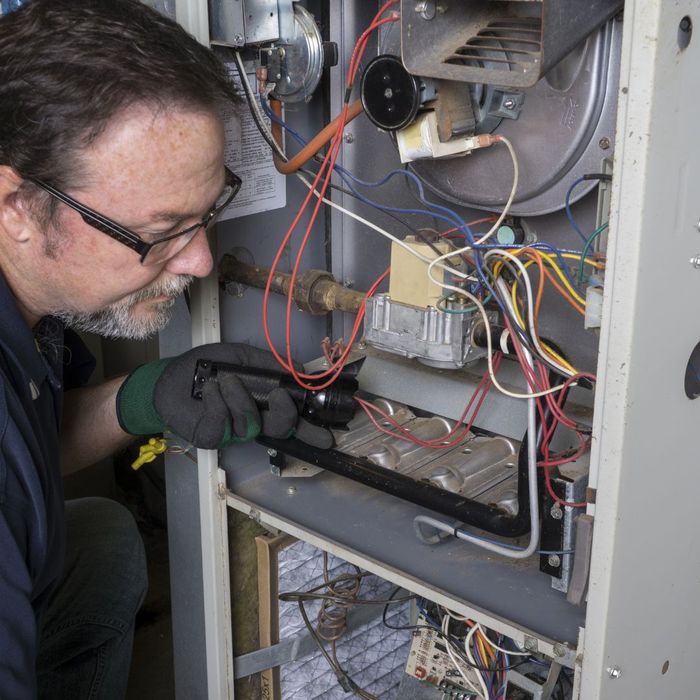 HVAC tech inspecting a furnace