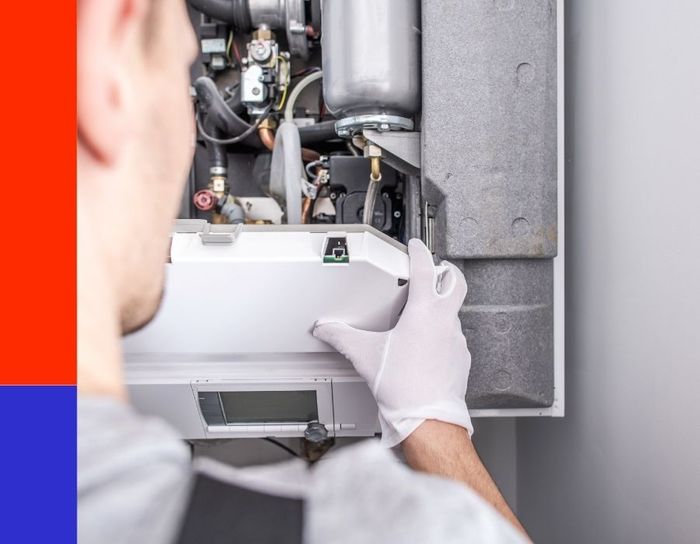 A professional HVAC technician wearing white safety gloves carefully removing a panel from a modern high-efficiency furnace to perform a detailed internal maintenance inspection.