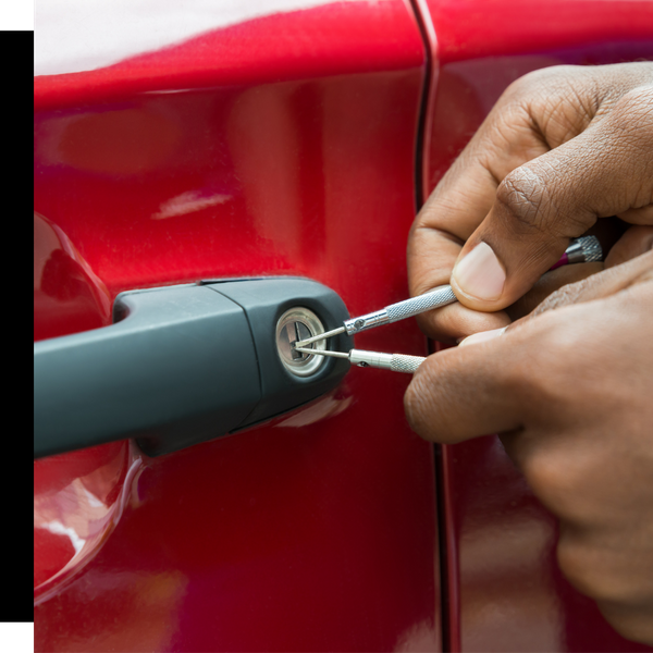 locksmith working on door of a red car