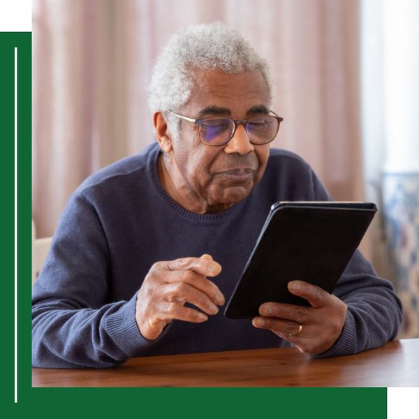 older man reading tablet