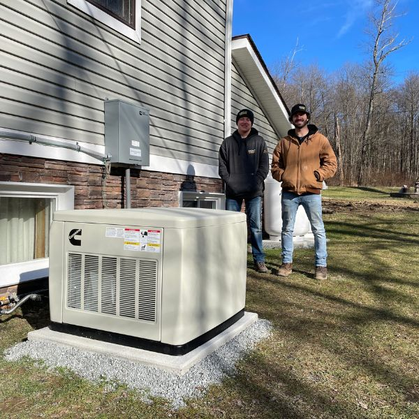 Technicians next to generator outside of home