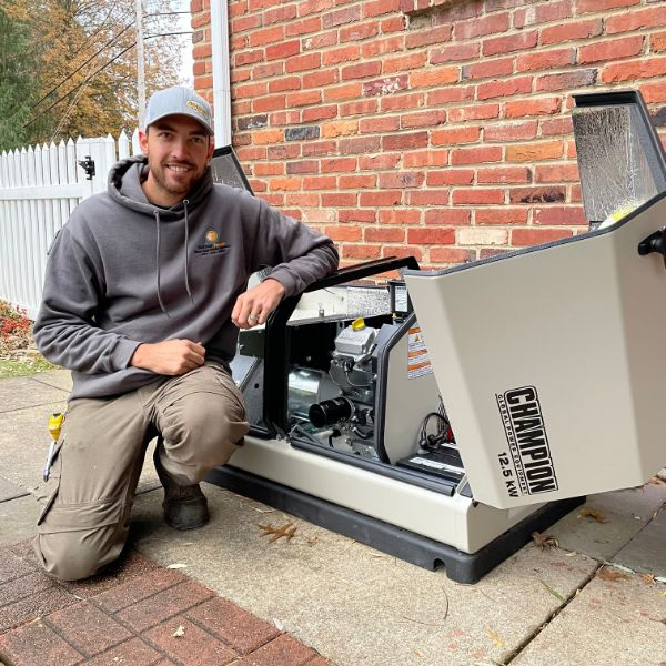 Technician smiling and leaning on generator