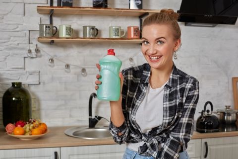 woman smiling holding dish soap