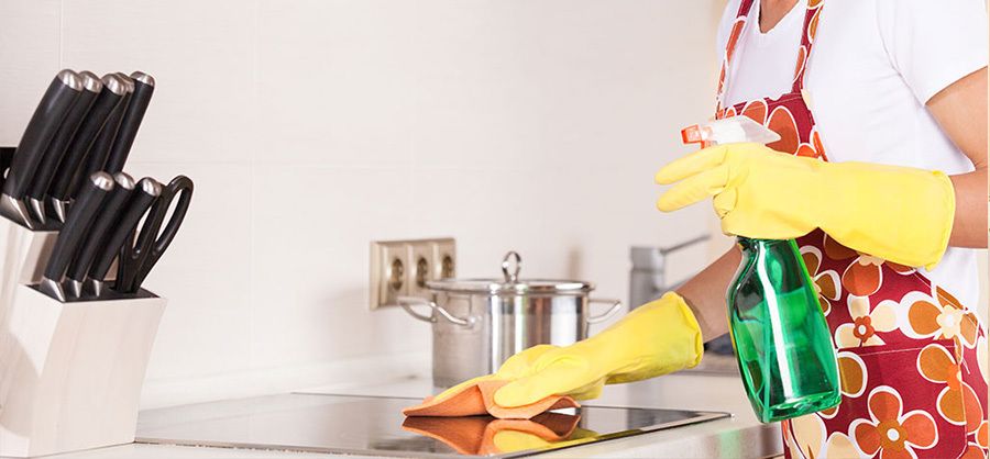 cleaning kitchen stove top with spray bottle