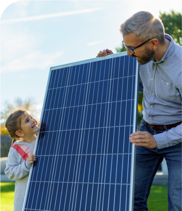 A father and daughter outside holding up a solar panel while smiling at each other 