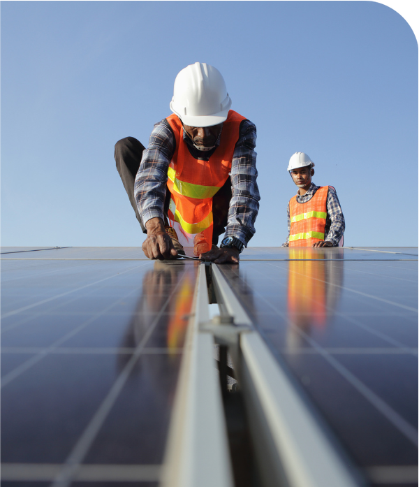 Two professional solar panel installers putting panels on a roof