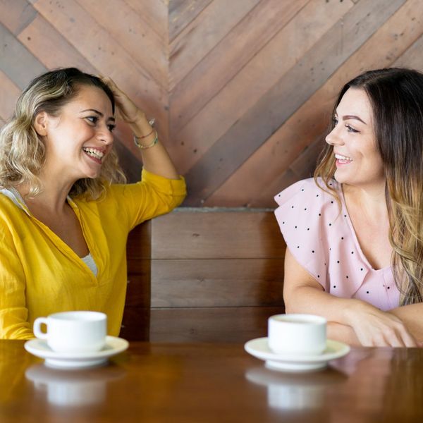 two woman chatting together at a table