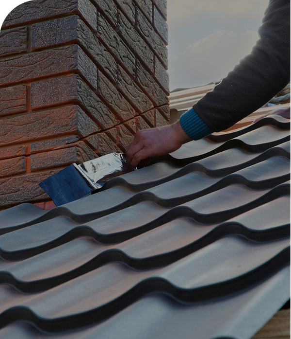 A roofer installing flashing around a chimney