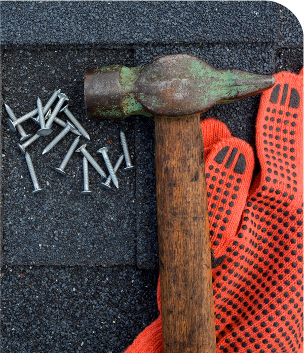 Hammer and and nails on shingles and gloves