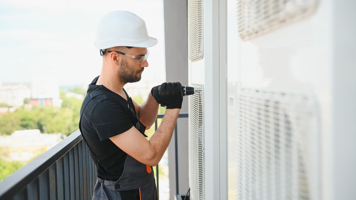 Technician servicing a commercial rooftop AC unit in South Florida