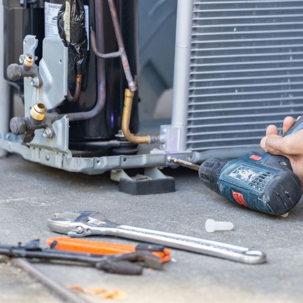 Person installing an AC unit. 