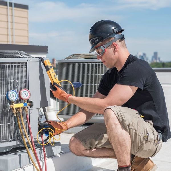 Man inspecting an AC unit. 