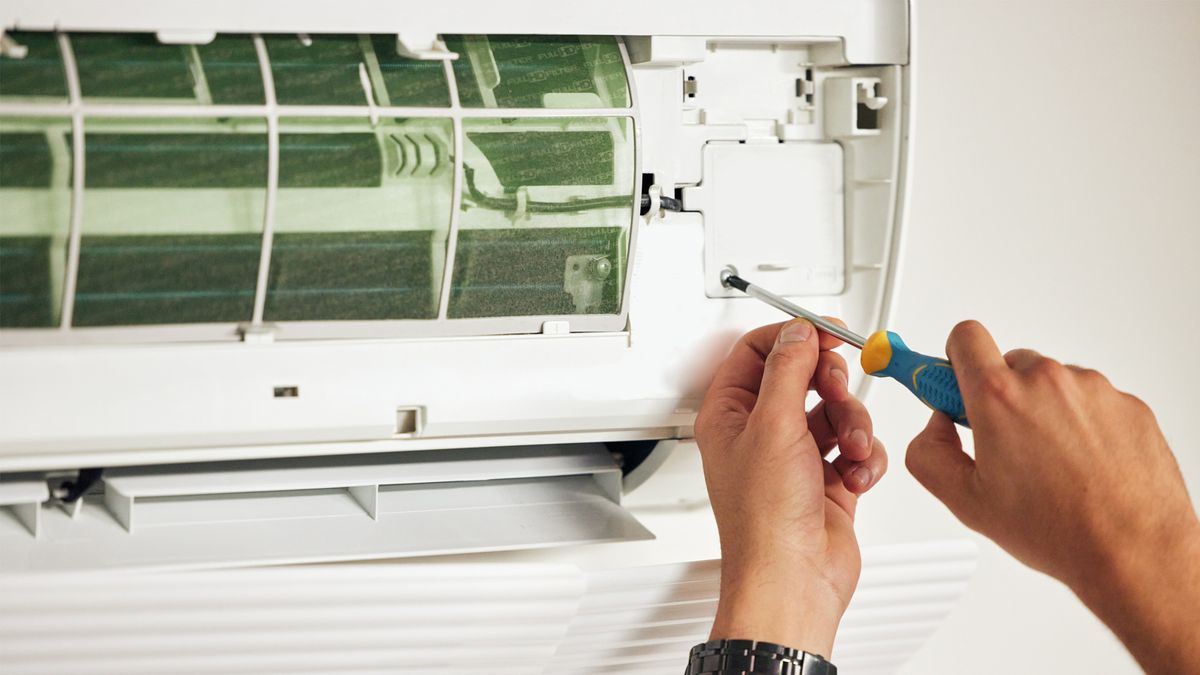 AC repair near me – professional HVAC repair technician fixing indoor air conditioner