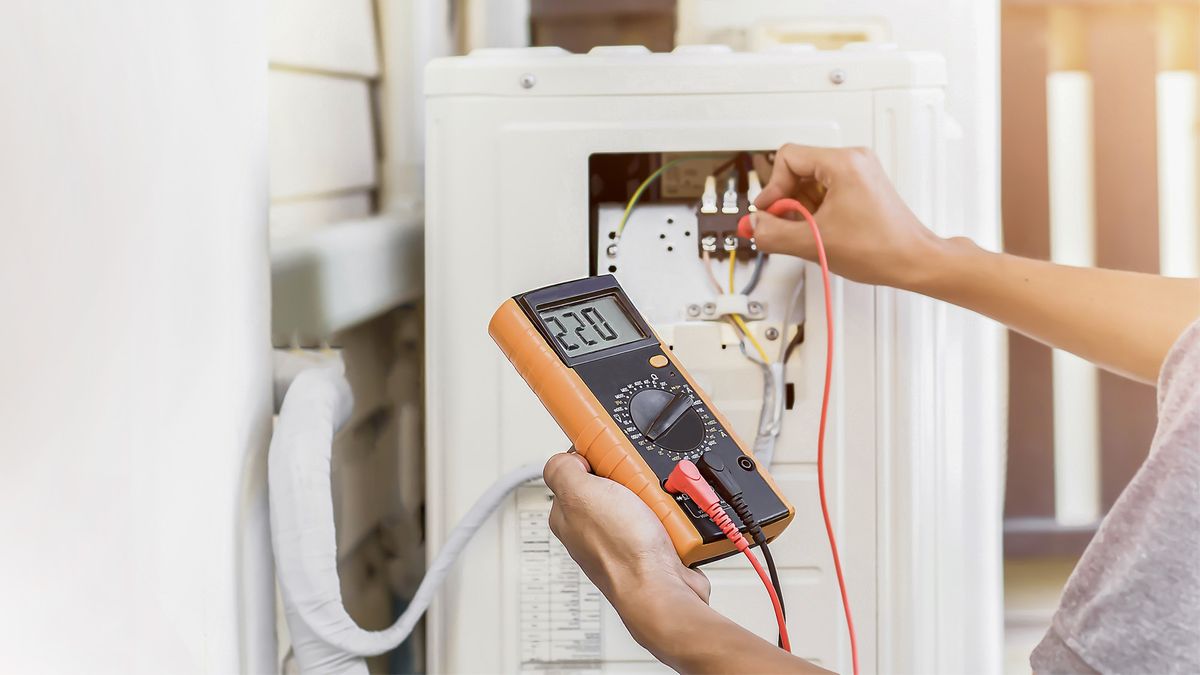HVAC technician testing voltage at the electrical terminals of an outdoor AC unit as part of an AC repair diagnosis in Greenacres, FL