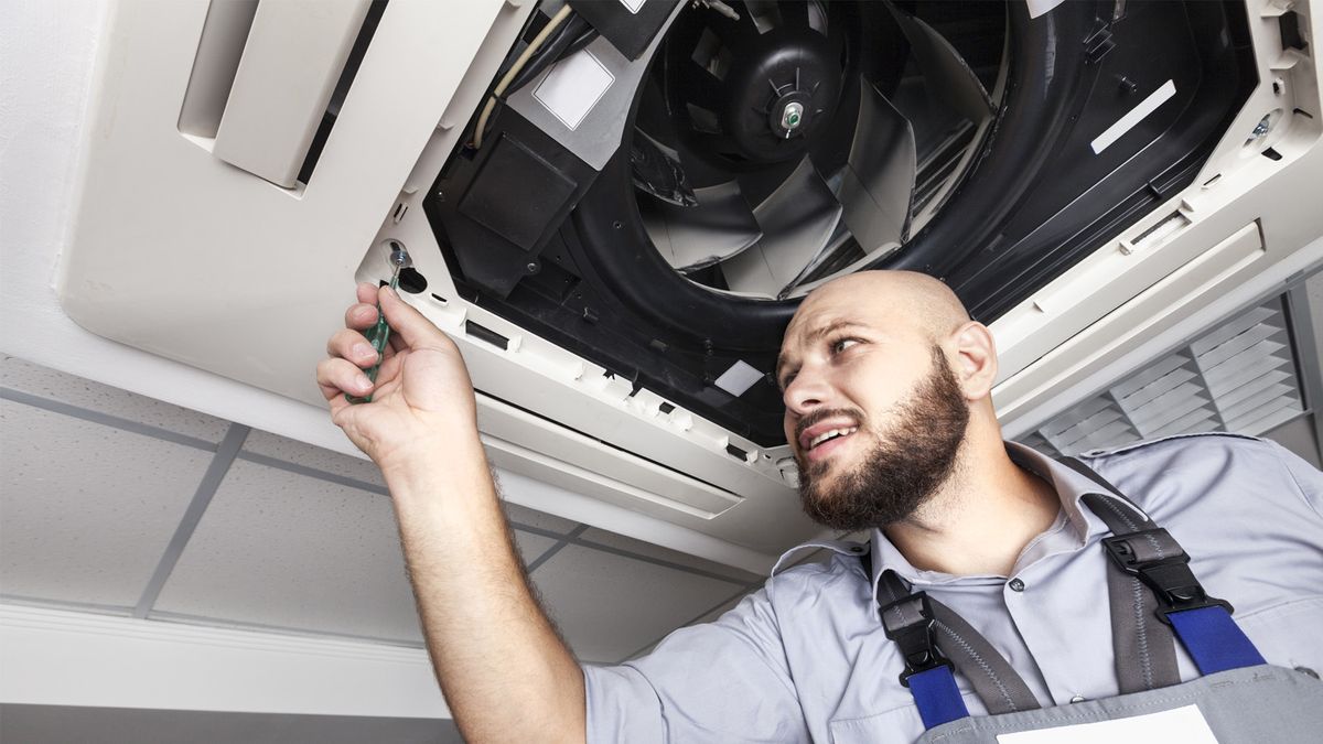 HVAC technician performing AC tune-up service in South Florida to improve cooling efficiency and system performance