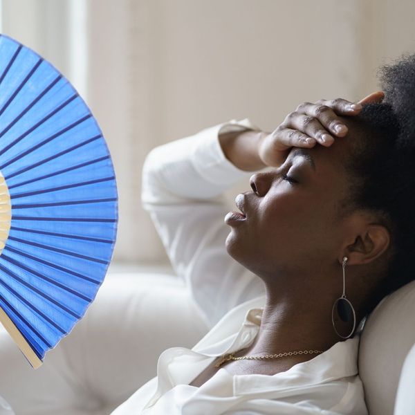 woman with hand on forehead, fanning herself from the heat