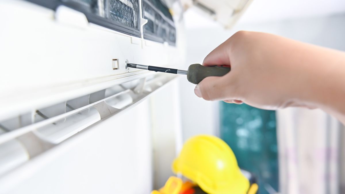 Daikin air conditioning repair technician servicing indoor AC unit