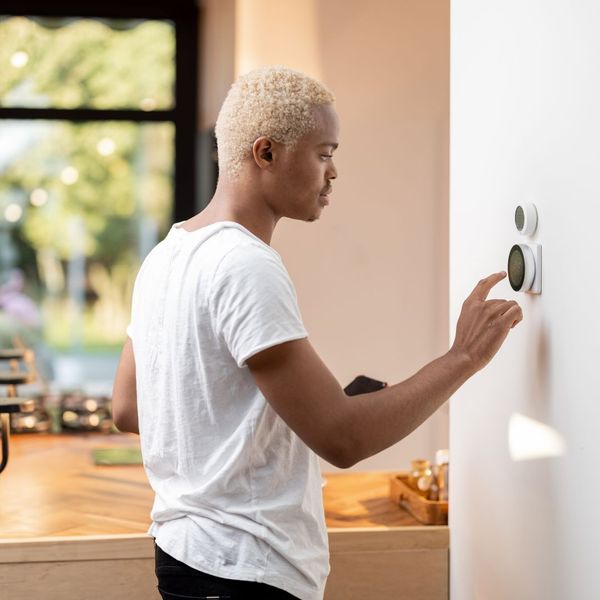 person adjusting thermostat