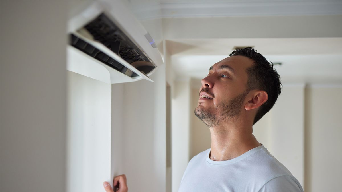 Homeowner checking AC unit during routine AC maintenance in South Florida