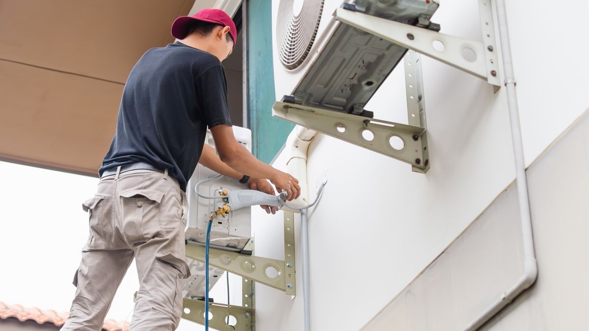 Residential HVAC Installation – Technician Installing Central Air Conditioner
