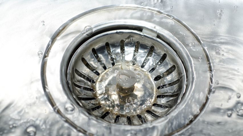 Professional drain cleaning removing buildup from kitchen sink drain