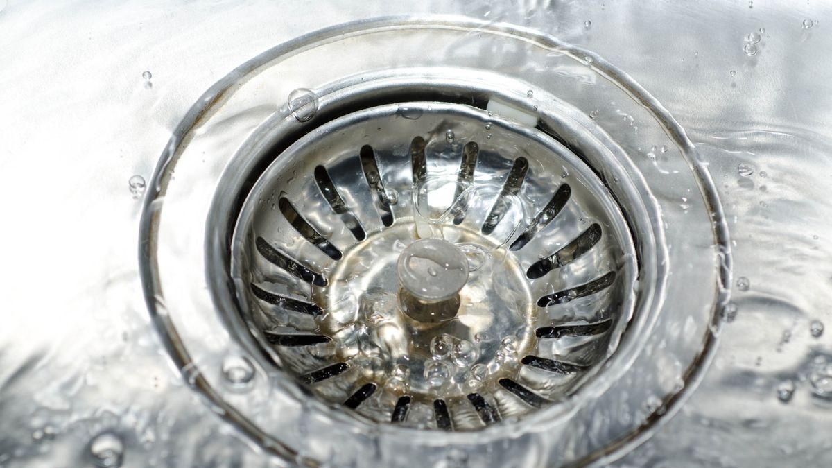 Professional drain cleaning removing buildup from kitchen sink drain