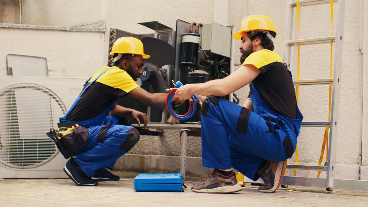 Two technicians repairing air conditioner in South Florida hvac technicians working with ac