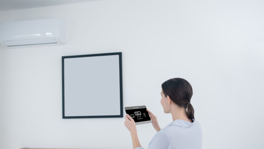 Woman Using Smart Tablet to Control LG HVAC System | LG HVAC Installers Near Me