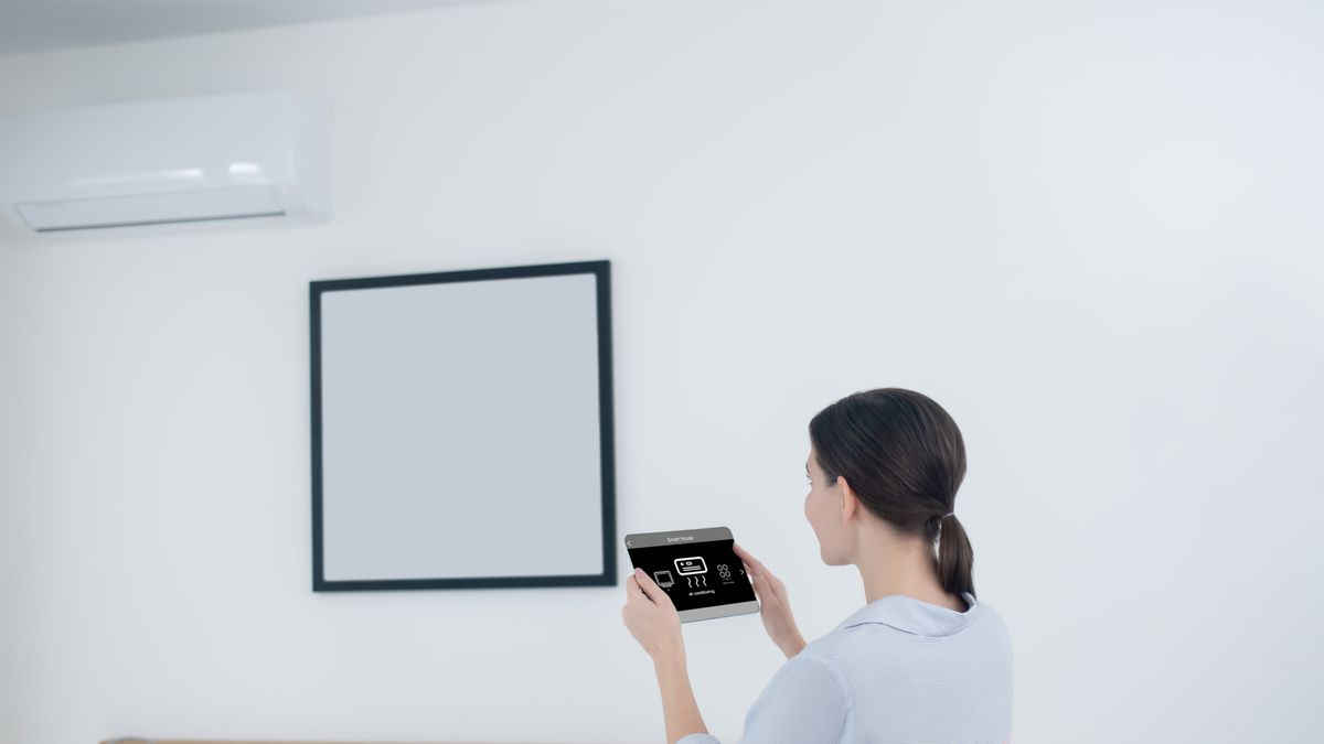 Woman Using Smart Tablet to Control LG HVAC System | LG HVAC Installers Near Me