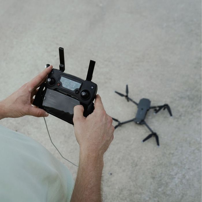 person holding controller for drone