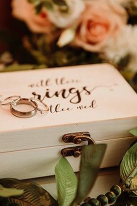 wedding rings sitting on top of wood ring box