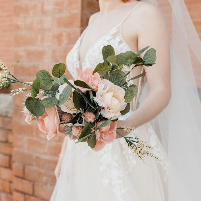 Close-up of a bride holding a pink and green floral wedding bouquet Close-up of a bride holding a pink and green floral wedding bouquet