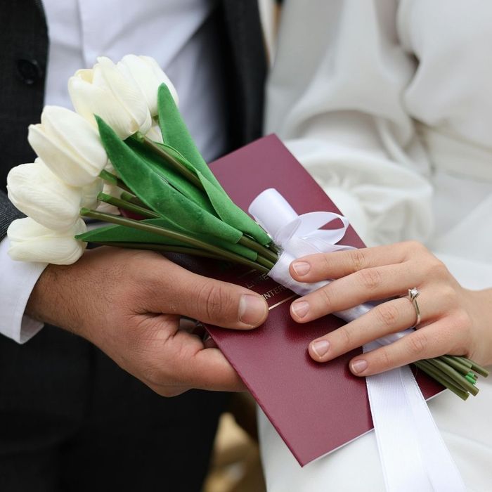 couple holding papers and flowers