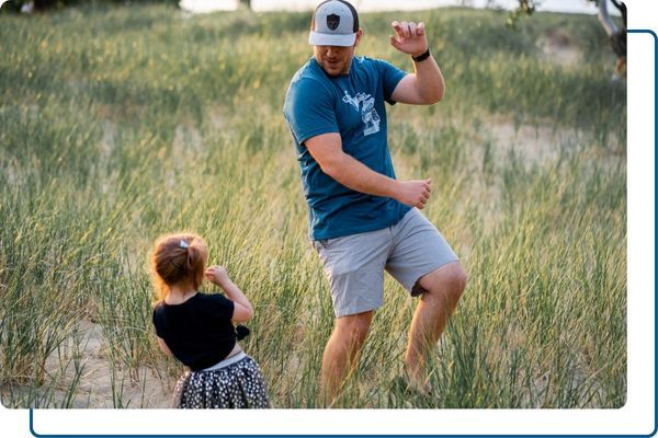 man dancing outdoors with daughter