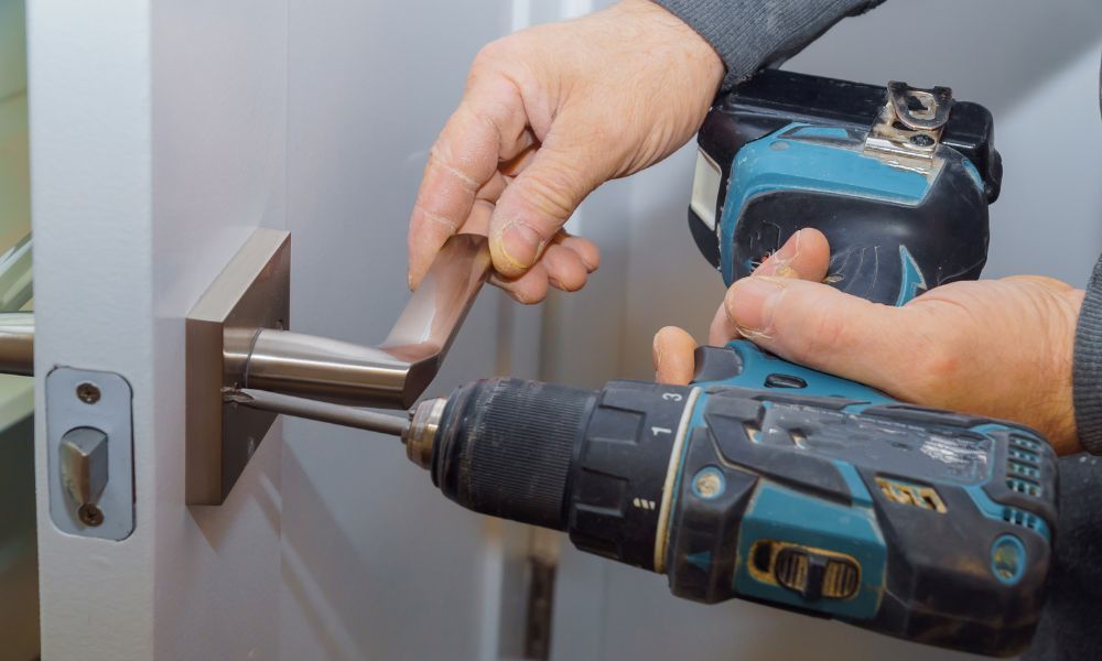 person drilling new lock into door handle