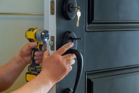 A person replacing a door handle