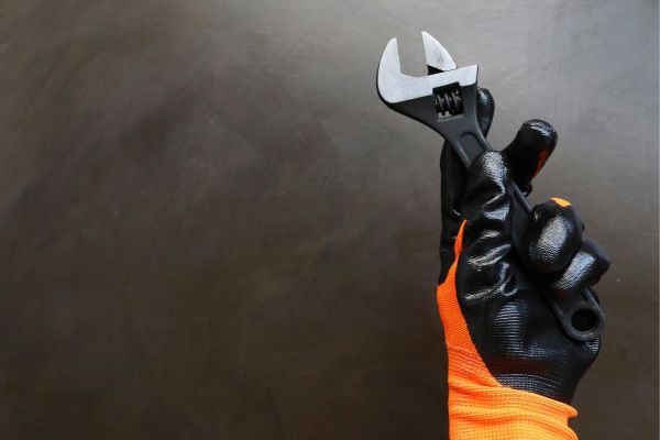 gloved hand holding a wrench services.jpg