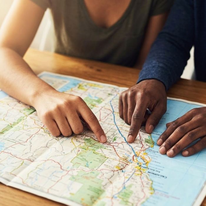 Hands trace a route on a map, planning a journey through California.