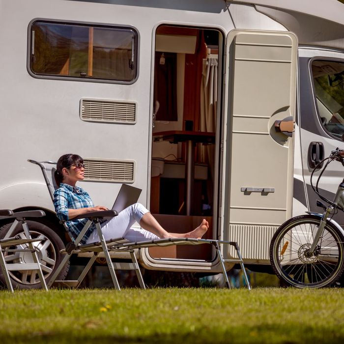 woman on laptop in front of camper