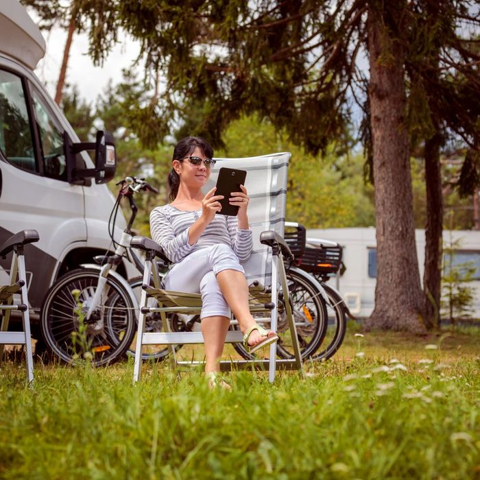 woman sitting outside of her campervan woman sitting outside of her campervan