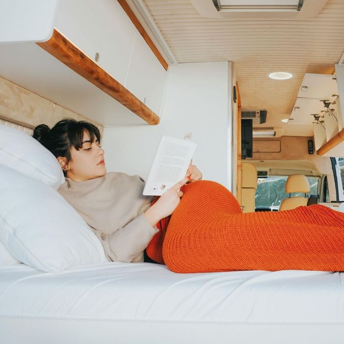 woman relaxes inside a used campervan 