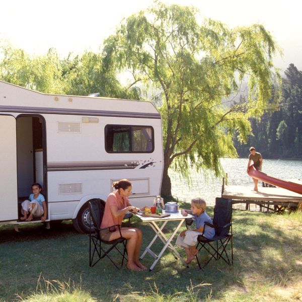 Family sitting outside their camper. 